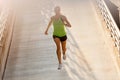 Young woman running on parking level in the city at sunset