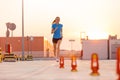 Young woman running on parking level in the city at sunset