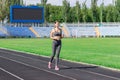 Young woman running on racetrack stadium. Training in the morning time. People sport and fitness concept Royalty Free Stock Photo