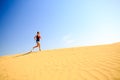 Young woman running on sand desert dunes Royalty Free Stock Photo