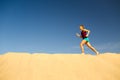 Young woman running on sand desert dunes Royalty Free Stock Photo