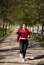 Young woman running and smiling in a park. health and training Royalty Free Stock Photo