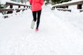 Young woman running on snow in winter mountains wearing warm clothing gloves in snow weather Royalty Free Stock Photo