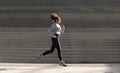 Young woman running by stairs Royalty Free Stock Photo