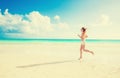 Young woman running on summer beach on coast of the ocean Royalty Free Stock Photo