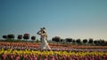 Young woman running in tulip field. Girl moving fast in flower garden. Royalty Free Stock Photo