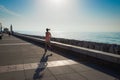 A young woman runs along the sea