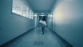 A young woman runs away from her pursuer along a dark corridor