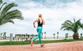 Young woman runs on the sea embankment. Active life style