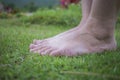 Young woman`s barefoot walking on the fresh, green grass in sunny summer in the morning. Restful moment. Healthy lifestyle. Brigh Royalty Free Stock Photo