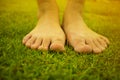 Young woman`s barefoot walking on the fresh, green grass in sunny summer in the morning. Restful moment. Healthy lifestyle. Brigh Royalty Free Stock Photo