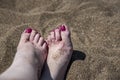 A young woman`s feet on a hot sand, close up Royalty Free Stock Photo