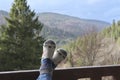 The young woman`s feet laid on the wooden railing on the background of the mountains. Royalty Free Stock Photo