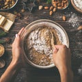 Young woman`s hands cooking christmas fruit cake. Wooden table with baking ingredients