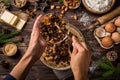 Young woman`s hands cooking christmas fruit cake. Wooden table w