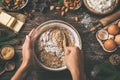 Young woman`s hands cooking christmas fruit cake. Wooden table w