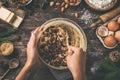 Young woman`s hands cooking christmas fruit cake. Wooden table w