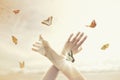 Woman`s hands dance in harmony with some butterflies in the middle of nature