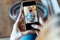 Young woman's hands photographing tempting burger on smartphone to upload on social media in a restaurant