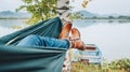 Young woman`s leather fashion boots photo. Female swinging in a hammock between the birch trees on the mountain lake bank. Out-of