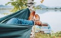 Young woman`s leather fashion boots photo. Female swinging in a hammock between the birch trees on the mountain lake bank. Out-of