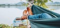 Young woman`s leather fashion boots photo. Female swinging in a hammock between the birch trees on the mountain lake bank. Out-of