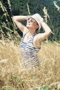 Young woman in sailor outfit smiles to the sun with hands behind Royalty Free Stock Photo