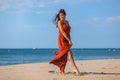 YOUNG WOMAN ON THE SAND OF THE BEACH