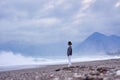 Young woman on the sand beach and watching the sea waves. Royalty Free Stock Photo