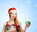 Young woman in santa hat with christmas attributes and little gi