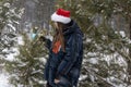 Young woman in santa hat with christmas ball in winter in forest Royalty Free Stock Photo