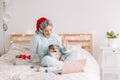 Young woman in Santa hat with cute puppy dog pet calling family friends on video call. Pet owner celebrating Christmas holiday Royalty Free Stock Photo