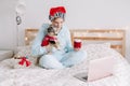 Young woman in Santa hat hold cute puppy dog and call friends family on video chat. Pet owner celebrating Christmas holiday alone Royalty Free Stock Photo