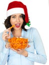 Young Woman in Santa Hat Holding a Bowl of Carrots Royalty Free Stock Photo