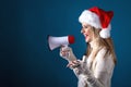 Young woman with santa hat holding a megaphone Royalty Free Stock Photo