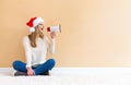 Young woman with santa hat holding a megaphone Royalty Free Stock Photo