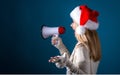 Young woman with santa hat holding a megaphone Royalty Free Stock Photo