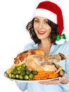 Young Woman in Santa Hat Holding Roast Turkey and Vegetables Royalty Free Stock Photo