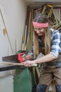 young woman sawing wooden slat