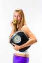 Young woman with scale under her arm and apple Royalty Free Stock Photo