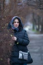 Young woman, in a scarf, stands in city park