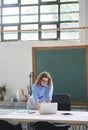 Young woman school teacher or employee standing at desk using laptop. Royalty Free Stock Photo