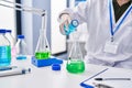 Young woman scientist measuring liquid at laboratory