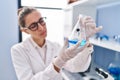 Young woman scientist measuring liquid at laboratory