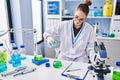 Young woman scientist measuring liquid at laboratory