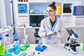 Young woman scientist measuring liquid writing on document at laboratory Royalty Free Stock Photo
