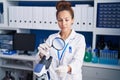 Young woman scientist using loupe holding pill at laboratory Royalty Free Stock Photo
