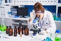 Young woman scientist using microscope working at laboratory Royalty Free Stock Photo