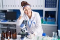 Young woman scientist using microscope working at laboratory Royalty Free Stock Photo