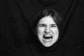 Young woman screaming, hate, rage. Crying emotional angry woman screaming on black background. Emotional, young female facial Royalty Free Stock Photo